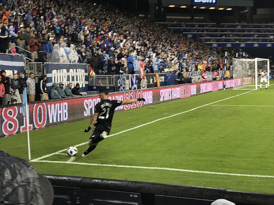 Jugador realizando un saque de esquina en un partido de fútbol